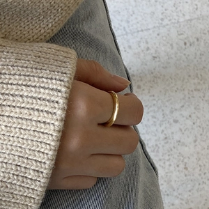 Minimalist polished gold tapered ring for women shown on hand with casual outfit