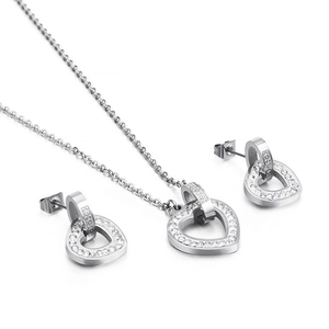 Silver heart necklace and earrings jewelry set with sparkling rhinestones on white background