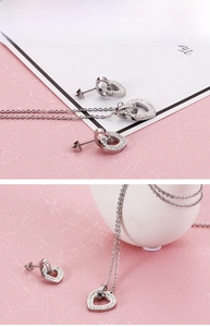 Macro detail of silver steel heart jewelry set with sparkling pavé cubic zirconia