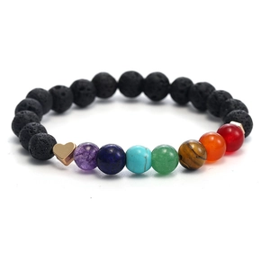 Macro detail of seven chakra beads and black lava stones with golden heart charm