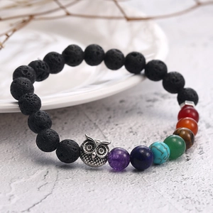 Detail of 7 chakra beads bracelet with black lava stone and silver owl charm accessory