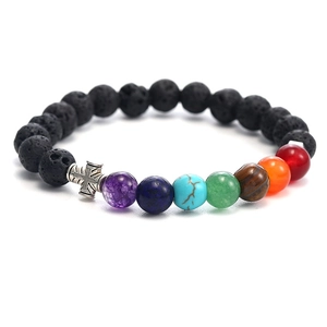 Detail of chakra stone bracelet with black lava beads and a silver cross pendant