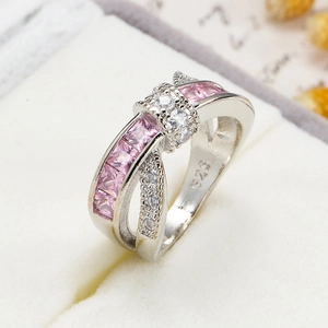 Macro shot of S925 silver cross ring with pink princess cut stones in jewelry box