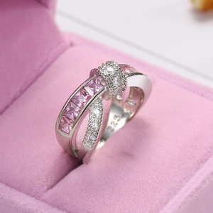 Macro view of crossover S925 silver ring with pink stones in a pink velvet box