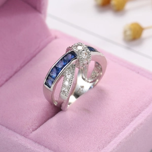 Macro detail of 925 silver crossover ring with blue zircons in a velvet gift box