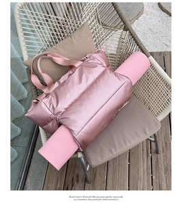Pink puffer fitness bag with yoga mat holder on a casual outdoor chair setup