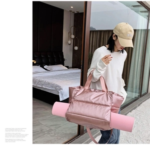 Pink quilted fitness bag with specialized side straps for carrying a yoga mat