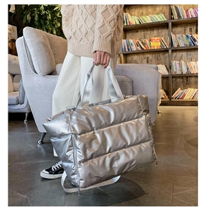 Model carrying a silver quilted fitness bag with waterproof material and metal sheen