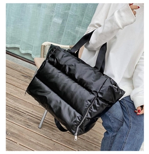 Close-up of black quilted puffer tote bag featuring durable nylon fabric and shoulder straps