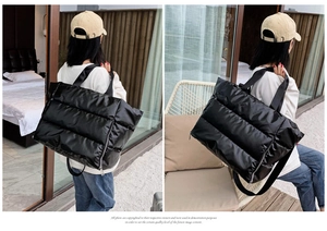Model wearing a large black quilted fitness bag for yoga or travel, showing size and scale