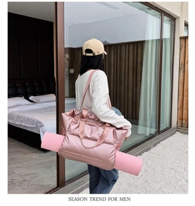 Pink waterproof fitness bag with dedicated yoga mat straps shown in a bright room
