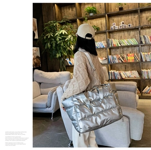 Silver quilted tote bag with metallic finish shown in a stylish indoor lifestyle setting