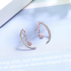Rose gold moon and star stud earrings with white zircons on minimalist background