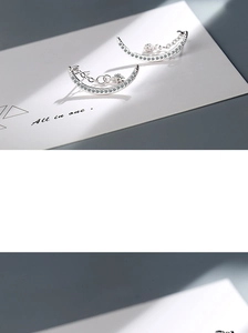 Macro shot of silver crescent moon stud earrings with zircon stars and dangling chains