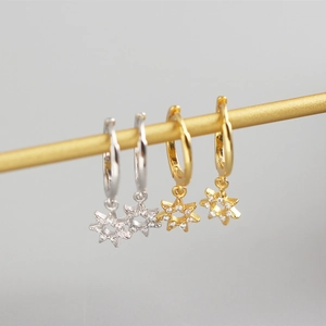 Detailed view of silver and gold S925 sterling silver star drop earrings with crystals