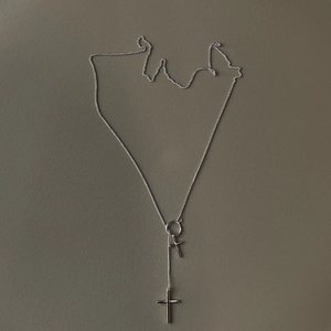 Detailed view of layered 925 sterling silver necklaces featuring double cross pendants