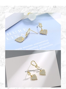 Detail of gold heart earrings with pavé crystals and elegant knot motif design