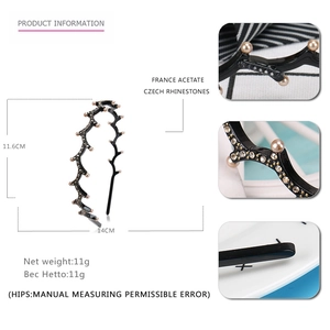 Detailed view of black acetate wavy headband featuring white pearls and Czech rhinestones