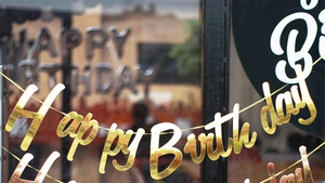 Close-up of golden metallic Happy Birthday banner for baby party decoration