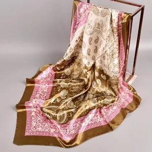 Macro detail of silk-like satin square scarf with paisley patterns in coffee and pink