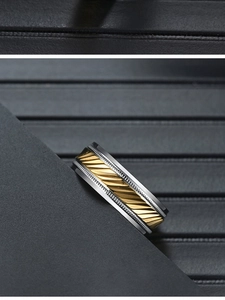 Macro detail of tricolor titanium steel ring showing gold knurled texture and silver edges