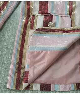 Dettaglio del blazer a righe con paillettes colorate, bottoni dorati e fodera rosa