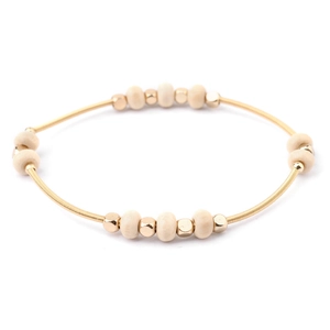 Detail of golden spring wire bracelet with beige wood beads and gold spacer beads