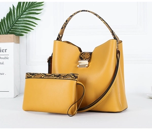 Detail of yellow tote and pouch set with snakeskin patterns and golden buckle