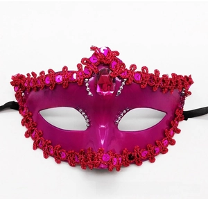 Detail of Venetian masquerade mask with purple finish, red lace, and pink gemstone