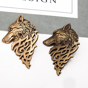 Retro bronze wolf head brooch pair with Celtic patterns on a professional jewelry card