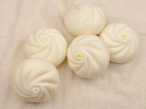 Macro shot of 5 realistic slow-rebound steamed bun squishy toys on linen fabric background