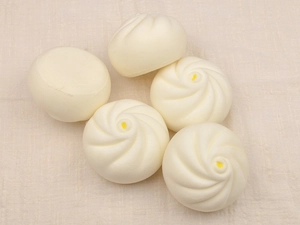 Detailed view of five PU foam slow rising steamed buns on a beige linen background cloth