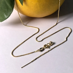 Adjustable gold plated box chain necklace with needle end and 925 tag on white background