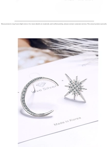 Macro detail of asymmetric star and moon earrings with cubic zirconia in silver finish