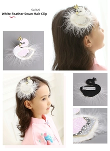 Detail of white swan hair clip with feather trim, gold crown and silver alligator clip