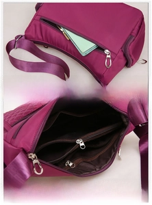 Detail of purple nylon crossbody bag showing the anti-theft back pocket and multi-layer interior