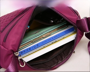 Detailed interior of purple nylon crossbody bag showing spacious capacity and books