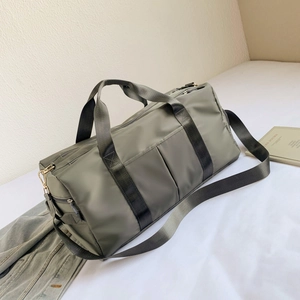 Detail of army green travel bag with shoe compartment on a minimalist white fabric background
