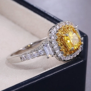 Détail macro d'une bague de luxe avec pierre jaune taille coussin et halo de diamants