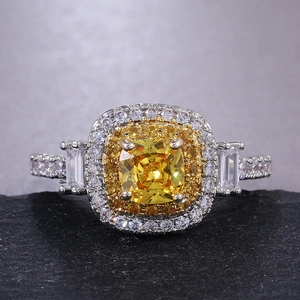 Détail macro d'une bague de luxe avec pierre jaune taille coussin et double halo de diamants