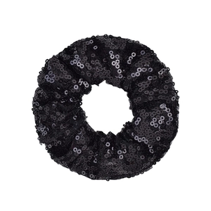 Detail of a black scrunchie with shimmering fish scale sequins on a white background