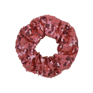 Close-up of red sequined hair scrunchie with shimmering fish scale pattern detail