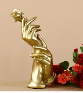 Detailed view of luxury gold resin sculpture showing hands holding a romantic rose ornament