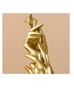 Macro detail of elegant golden hand sculpture holding a rose for luxury home decor