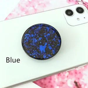 Blue glitter foil retractable phone grip socket with starry sky effect on a white phone