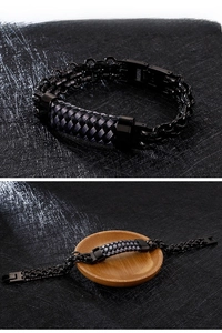 Macro detail of men's black woven bracelet with stainless steel chains and clasp