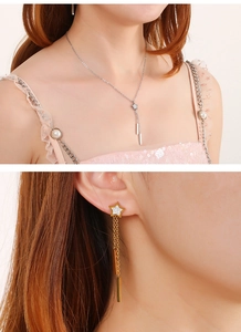 Détail du collier étoile et des boucles d'oreilles étoiles portés par un mannequin