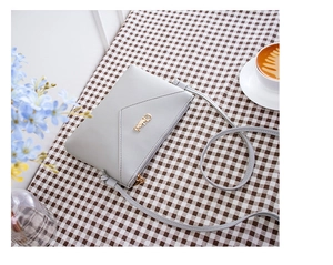 Gray faux leather crossbody phone bag with litchi texture and gold metal logo on grid cloth