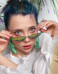 Detail of rimless geometric sunglasses with green gradient lenses and metal bridge