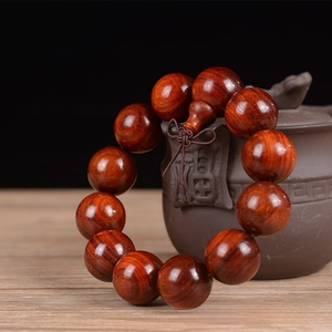 Detailed view of 20mm sandalwood prayer beads with natural wood grain and small holes